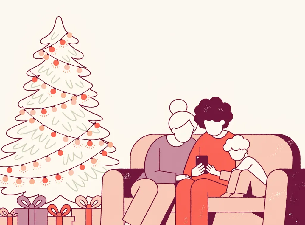 Une grand-mère, un parent et un enfant assis sur un canapé près du sapin regardent ensemble une liste sur un smartphone, cadeaux emballés au pied du sapin